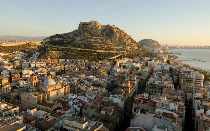 Alicante cityscape with Santa Bárbara Castle on a hill during a self-guided walking tour.