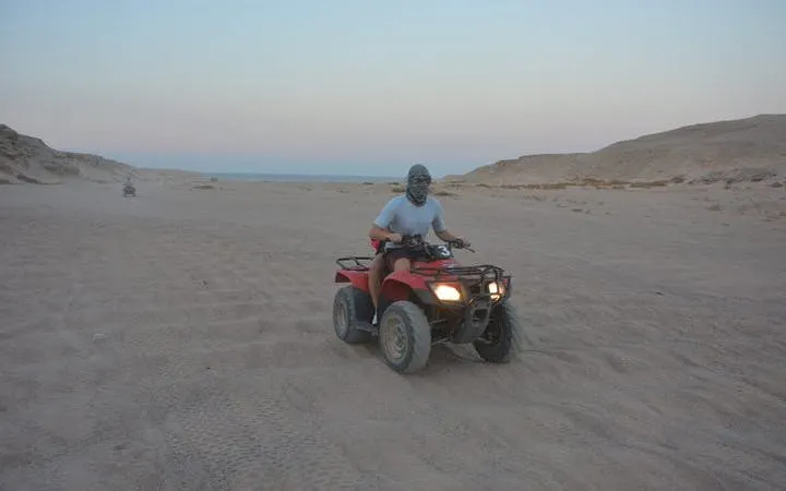 ATV quad bike rider on desert safari at sunset, Sharm El Sheikh.