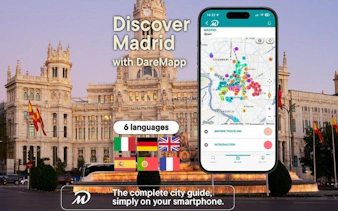Madrid walking tour app displayed on smartphone with city map in front of Palacio de Cibeles.