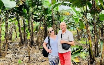 Couple exploring banana plantation on Hanoi countryside Vespa tour.