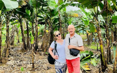 Couple exploring banana plantation on Hanoi countryside Vespa tour.