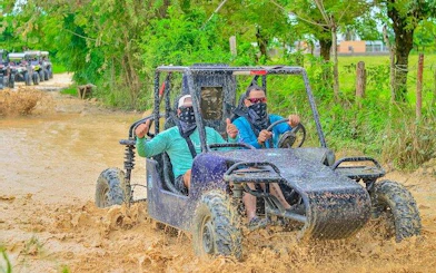 Buggy driving through muddy jungle trail in Punta Cana tour.