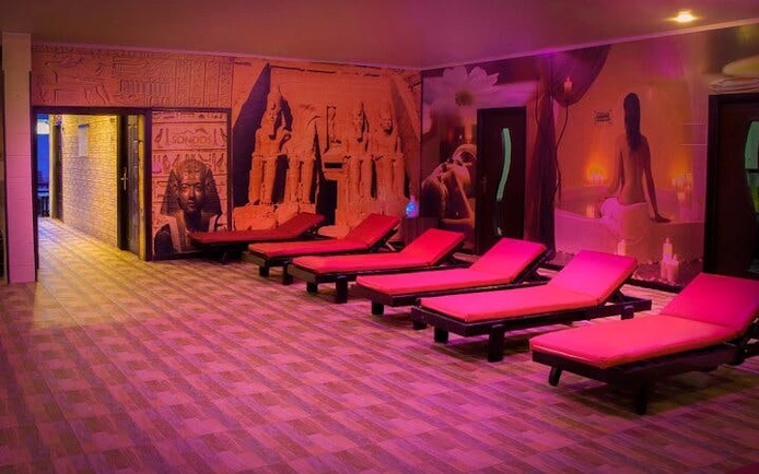 Loungers in a dimly lit Moroccan hammam with wall art, Marrakech.