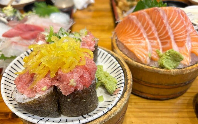 Sushi and sashimi dishes on a table during a Shinjuku bar hopping tour in Tokyo.