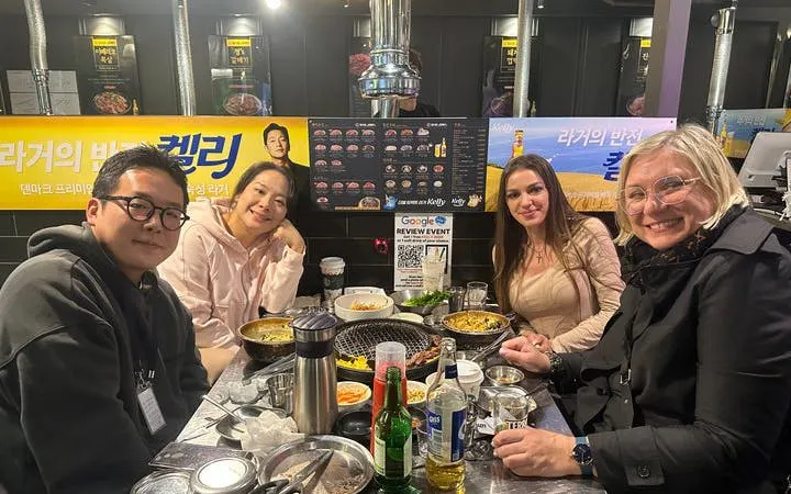 Group enjoying Korean BBQ dinner in Gangnam restaurant during walking tour.