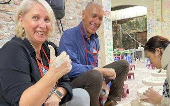 Participants crafting pottery at Bat Trang Ceramic Village during Hanoi Vespa tour.