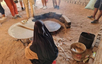 Woman preparing traditional bread on sand during ATV safari in Sharm El Sheikh.