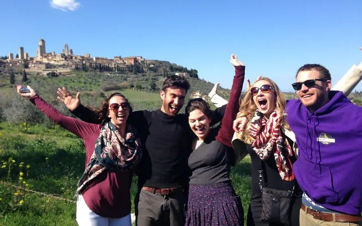 Group enjoying Chianti wineries tour with San Gimignano in the background.