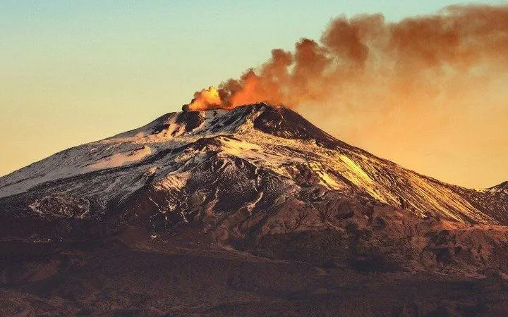 Mount Etna emitting smoke during sunset, part of Catania Self-Guided Walking Tour.