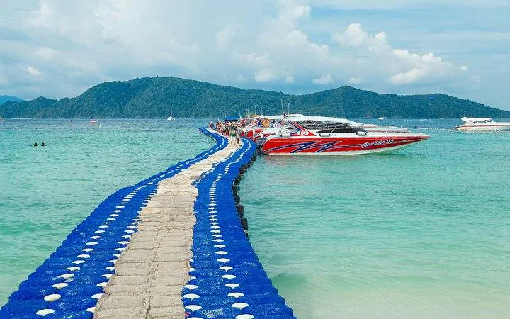 Speedboat docked at Coral Island with floating pier, Phuket tour.