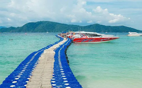 Speedboat docked at Coral Island with floating pier, Phuket tour.