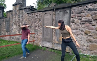 Participants reenacting a Harry Potter scene with wands at Greyfriars Kirkyard, Edinburgh.