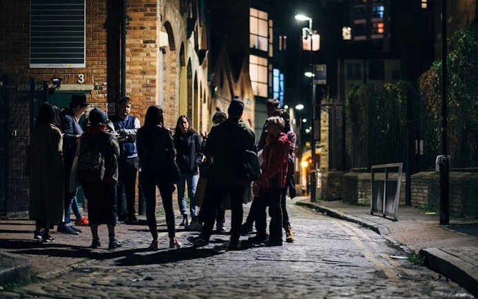 Group on York haunted history walking tour at night on cobblestone street.