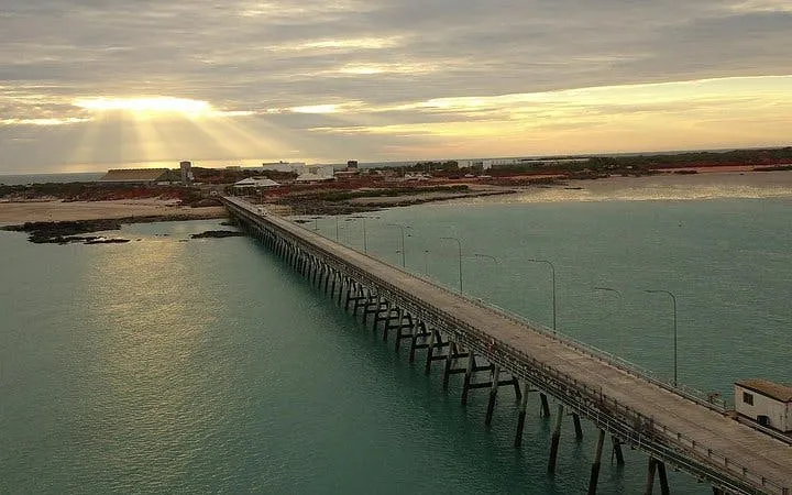 Jetty extending into turquoise waters at sunset, Broome, Australia, featured in Aditya Self-Guided Audio Tour.
