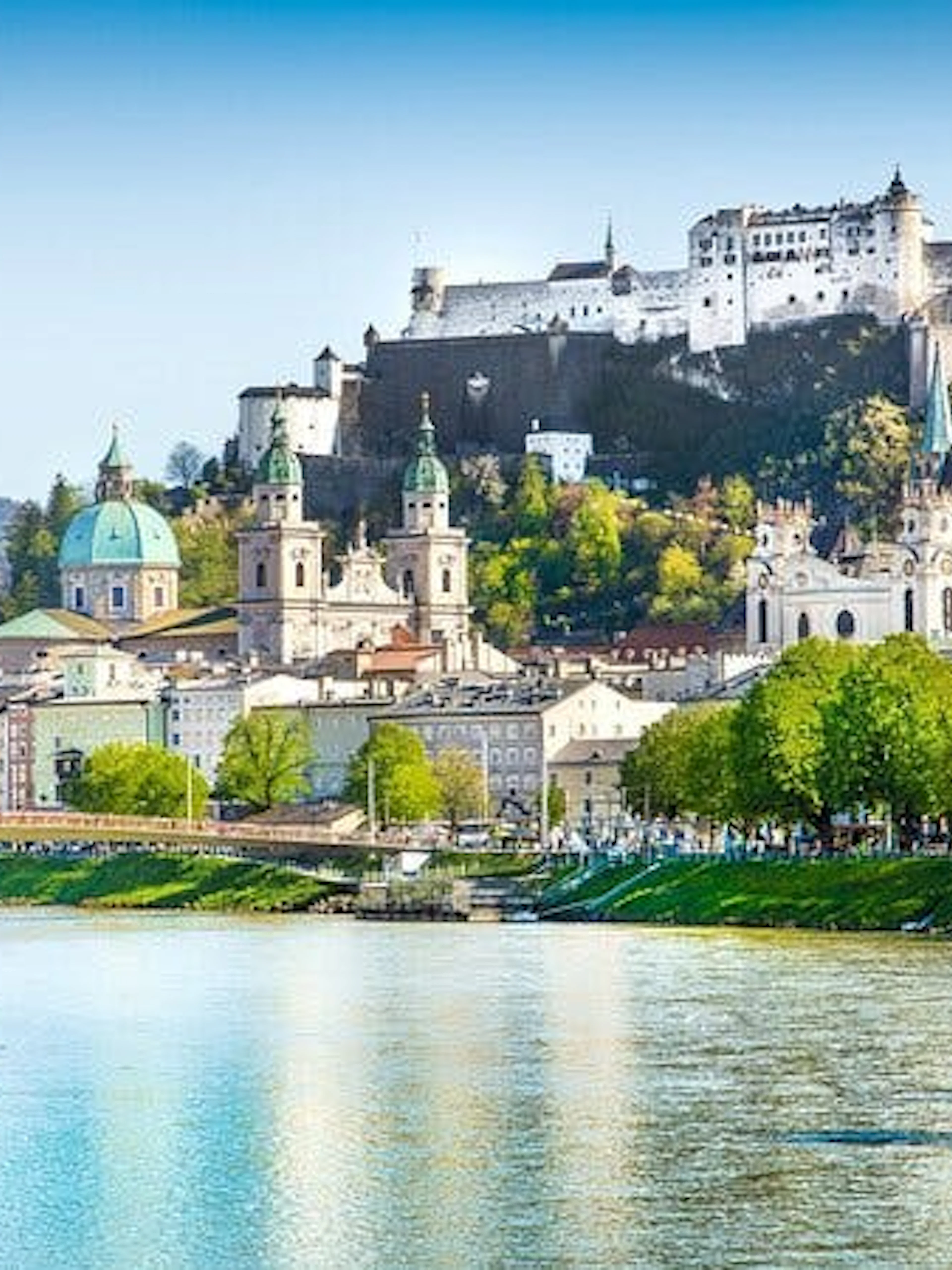 Salzburg cityscape with Hohensalzburg Fortress and Salzach River.