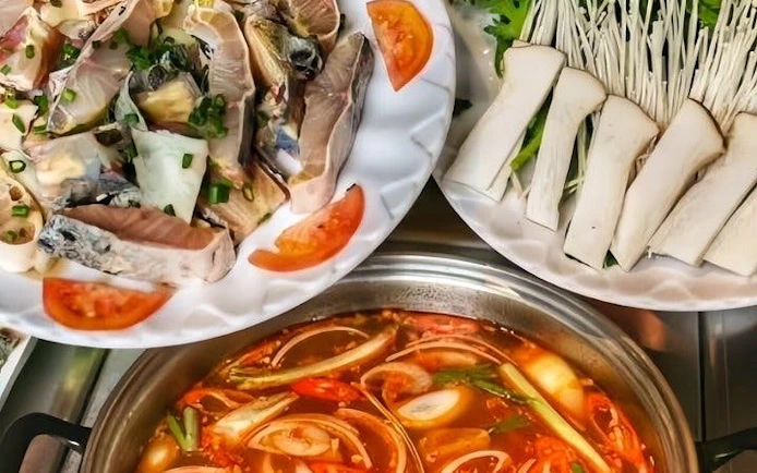 Sapa hotpot meal with fresh fish, mushrooms, and vegetables on a guided local market tour.