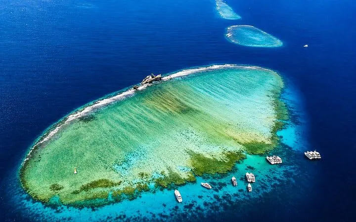 Tiran Island aerial view with boats, coral reefs, and clear blue water near Sharm El-Sheikh.