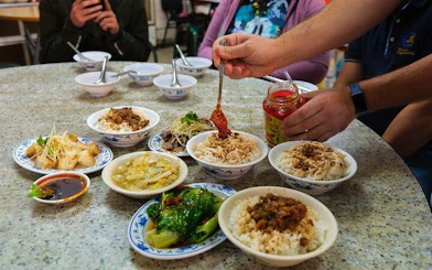 Taipei food tour with locals sampling traditional dishes at a table.