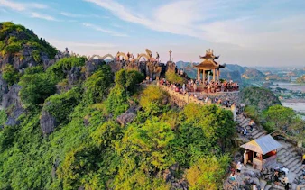 Mua Cave viewpoint with tourists overlooking Ninh Binh landscape, Vietnam.