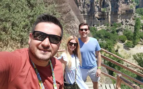 Tourists enjoying a scenic view in Cappadocia with rock formations in the background.