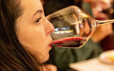 Person tasting red wine during Tuscany small-group wine tour.