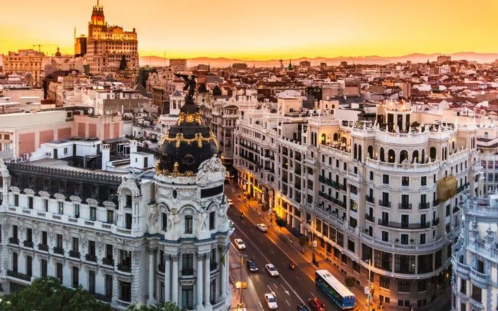 Madrid cityscape at sunset, featuring Gran Vía buildings, part of self-guided walking tour.