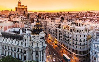 Madrid cityscape at sunset, featuring Gran Vía buildings, part of self-guided walking tour.