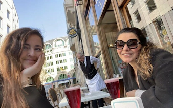 Two people enjoying drinks at an outdoor café in Old Town Brussels.