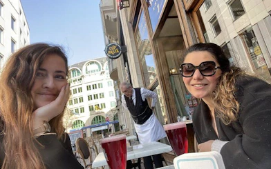 Two people enjoying drinks at an outdoor café in Old Town Brussels.