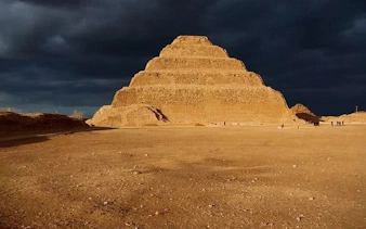 Step Pyramid of Djoser at Saqqara under a dramatic sky, part of a guided tour with Egyptologist.