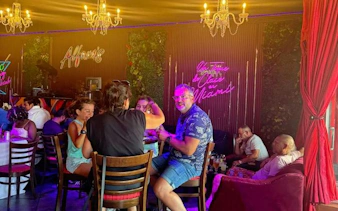 Group enjoying Cuban food and music in a vibrant cafe on Calle Ocho, Little Havana, Miami.