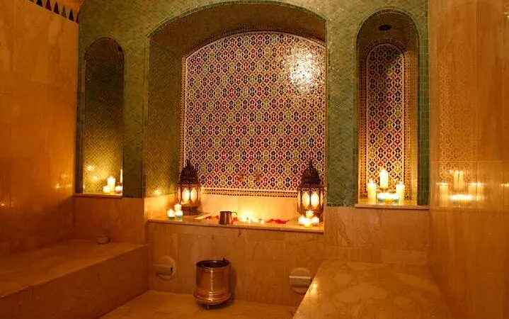 Luxurious Moroccan hammam with candles and ornate tiles in Marrakesh.