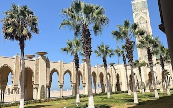 Hassan II Mosque arches and palm trees in Casablanca during Marrakesh excursion.