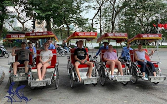 Cyclo riders and tourists in Hanoi's Old Quarter during a private tour.