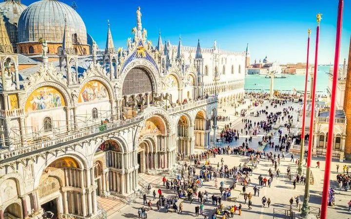 St. Mark's Basilica and Square bustling with tourists in Venice during a self-guided walking tour.