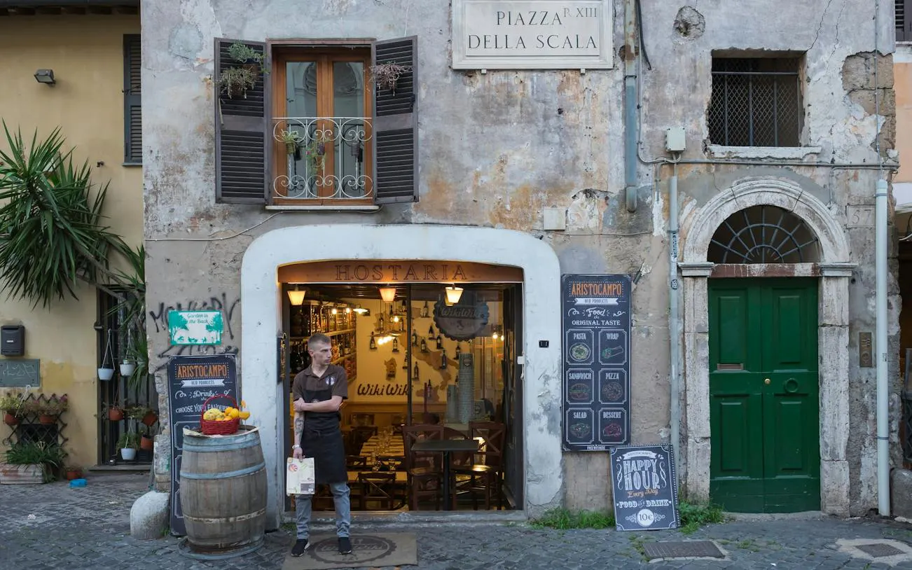 Hostaria entrance in Trastevere, Rome, with a person standing outside near a menu board.
