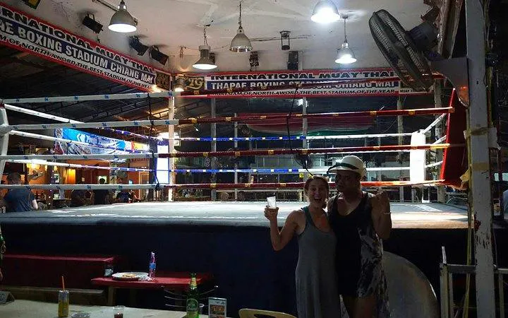 Muay Thai boxing ring at Thapae Stadium, Chiang Mai, with spectators nearby.