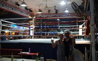 Muay Thai boxing ring at Thapae Stadium, Chiang Mai, with spectators nearby.