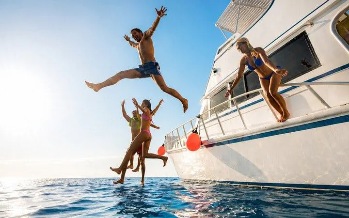 Tourists jumping off a boat into the sea during Tiran Island snorkeling trip from Sharm El-Sheikh.