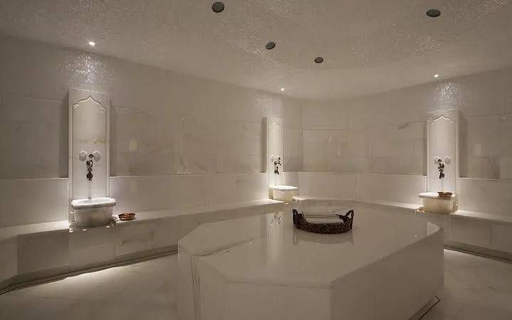 Turkish bath interior with marble benches and basins, Hurghada spa experience.