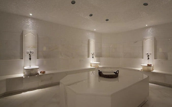 Turkish bath interior with marble benches and basins, Hurghada spa experience.