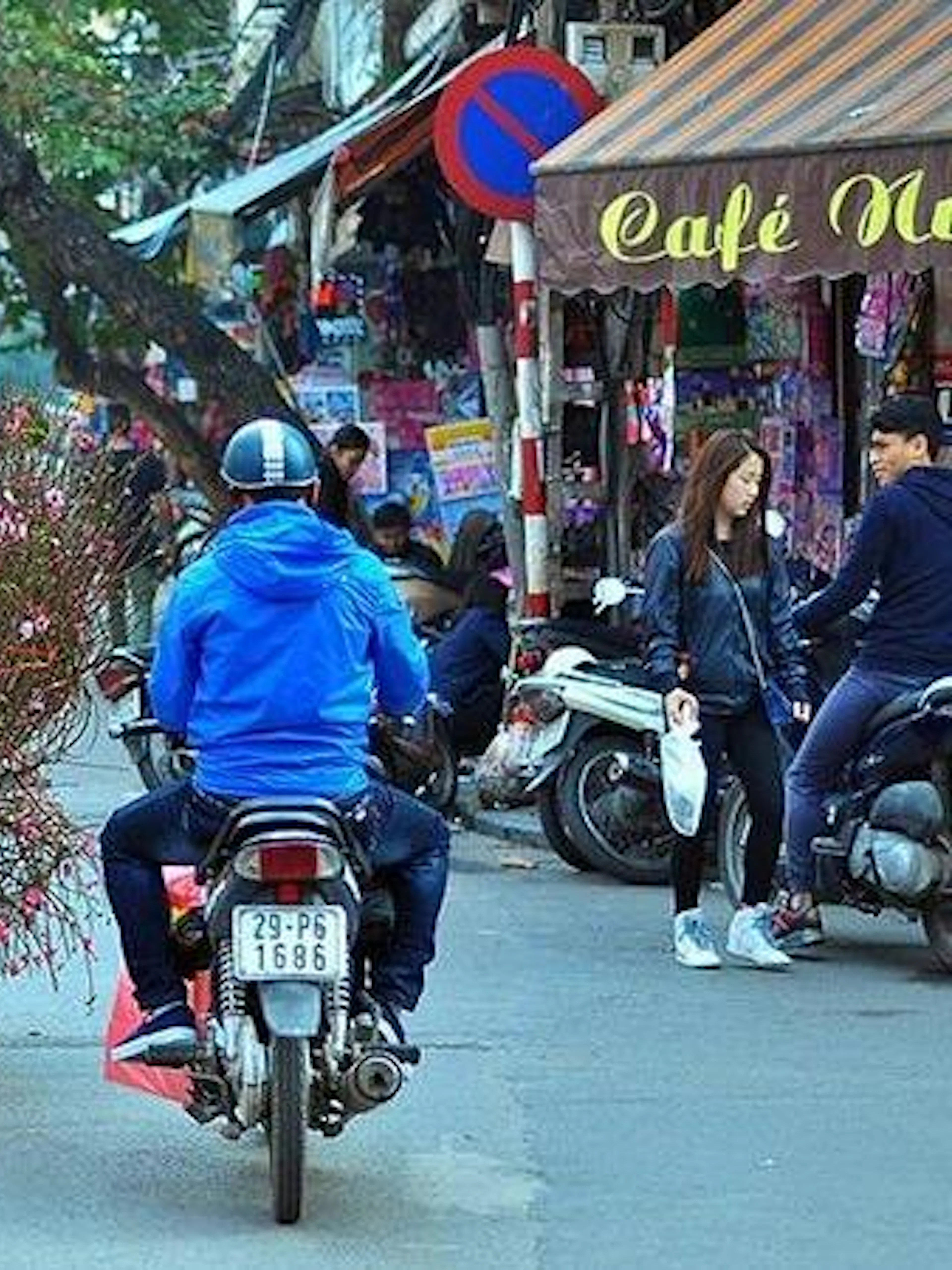 Cyclo carrying flowers through Hanoi's Old Quarter street.