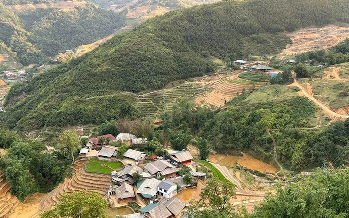 Sapa village and terraced rice fields viewed from above, showcasing lush green hills.