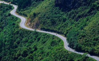 Winding road through lush green hills on Sapa motorbike tour route.