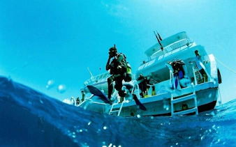 Scuba divers entering water from boat, Sharm El Sheikh.