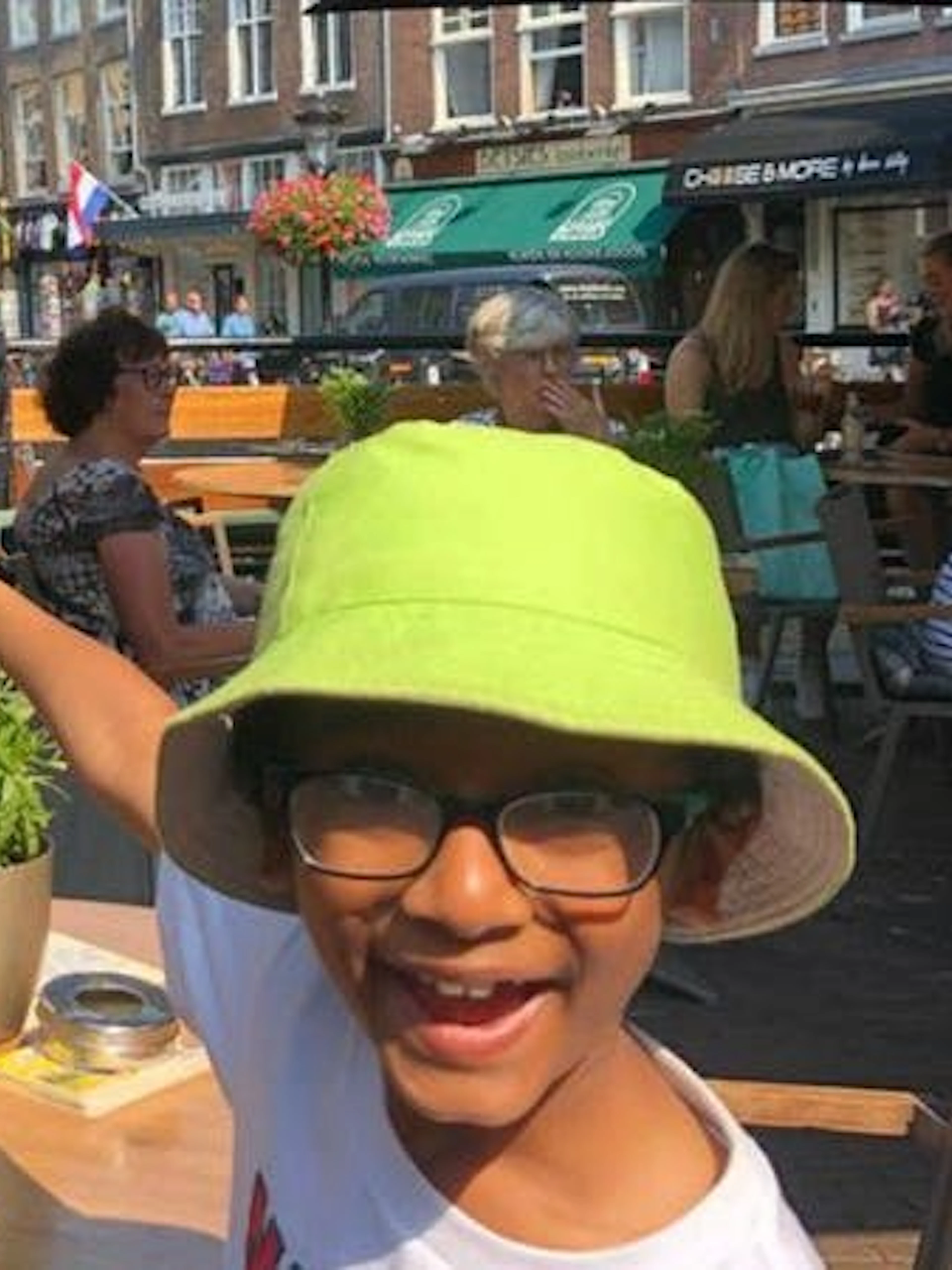 Child pointing at statue in Utrecht café during self-guided city exploration game.