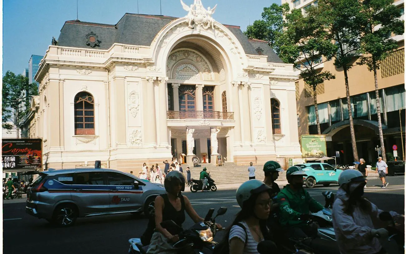 Ho Chi Minh City Opera House with motorbikes and taxis in front, part of French Quarter tour.