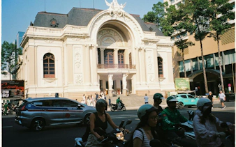 Ho Chi Minh City Opera House with motorbikes and taxis in front, part of French Quarter tour.