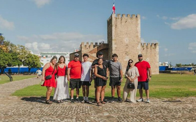 Group of tourists in front of historic Fortaleza Ozama in Santo Domingo during a day tour from Punta Cana.