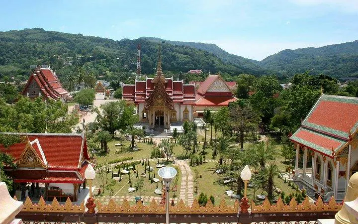 Wat Chalong temple complex surrounded by lush greenery in Phuket, Thailand.